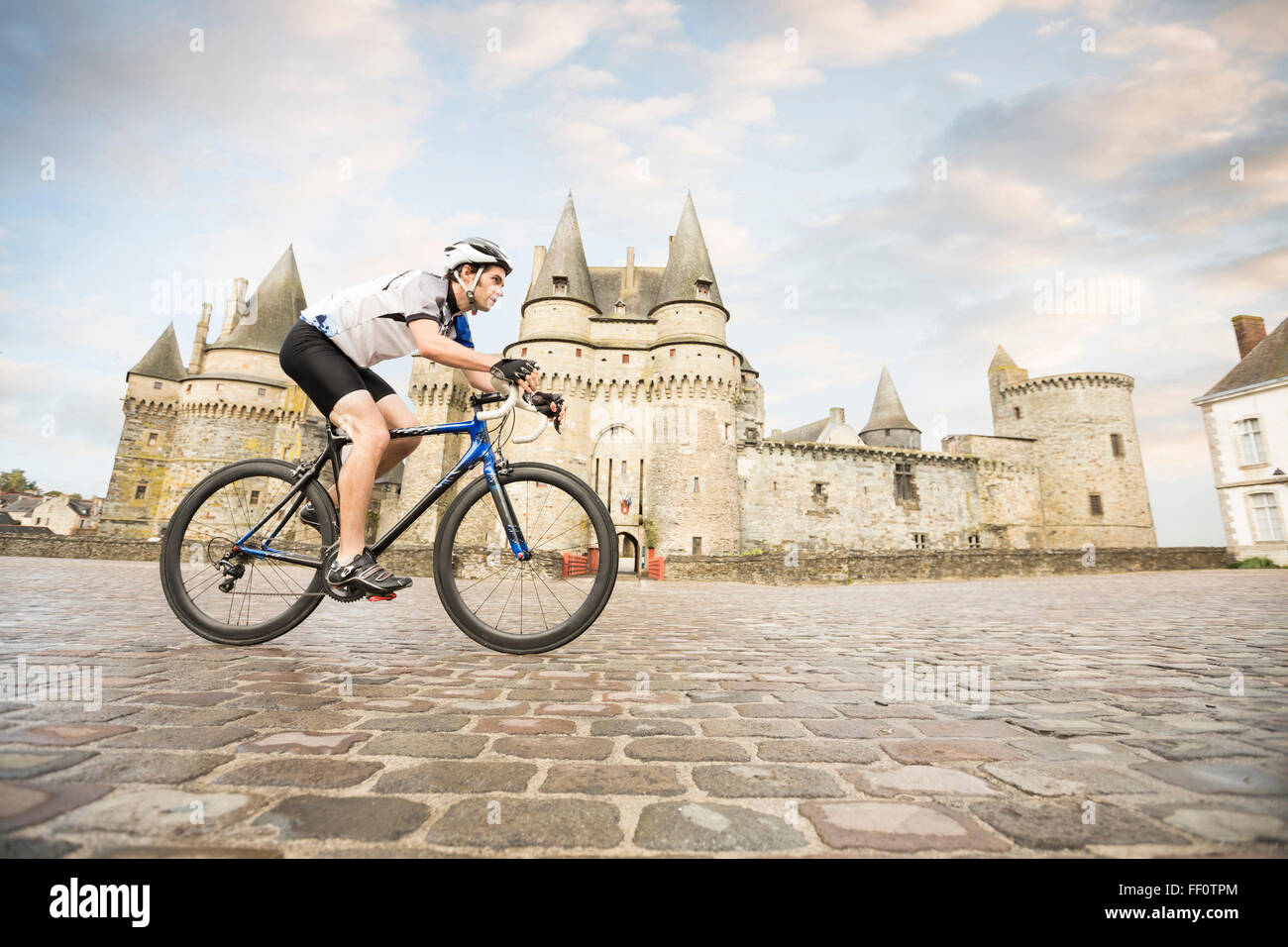 Caucasian man cycling near castle Stock Photo