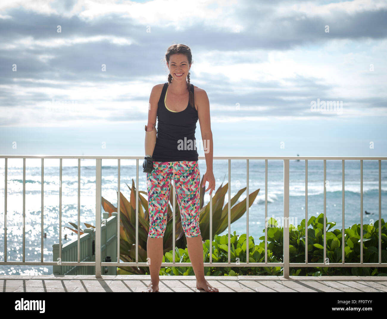 Mixed race amputee athlete smiling on balcony Stock Photo