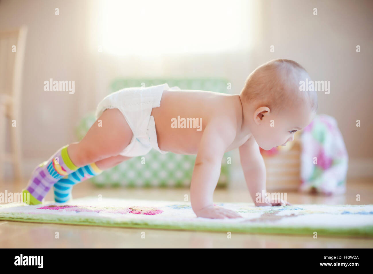 Mixed race baby girl playing on floor Stock Photo
