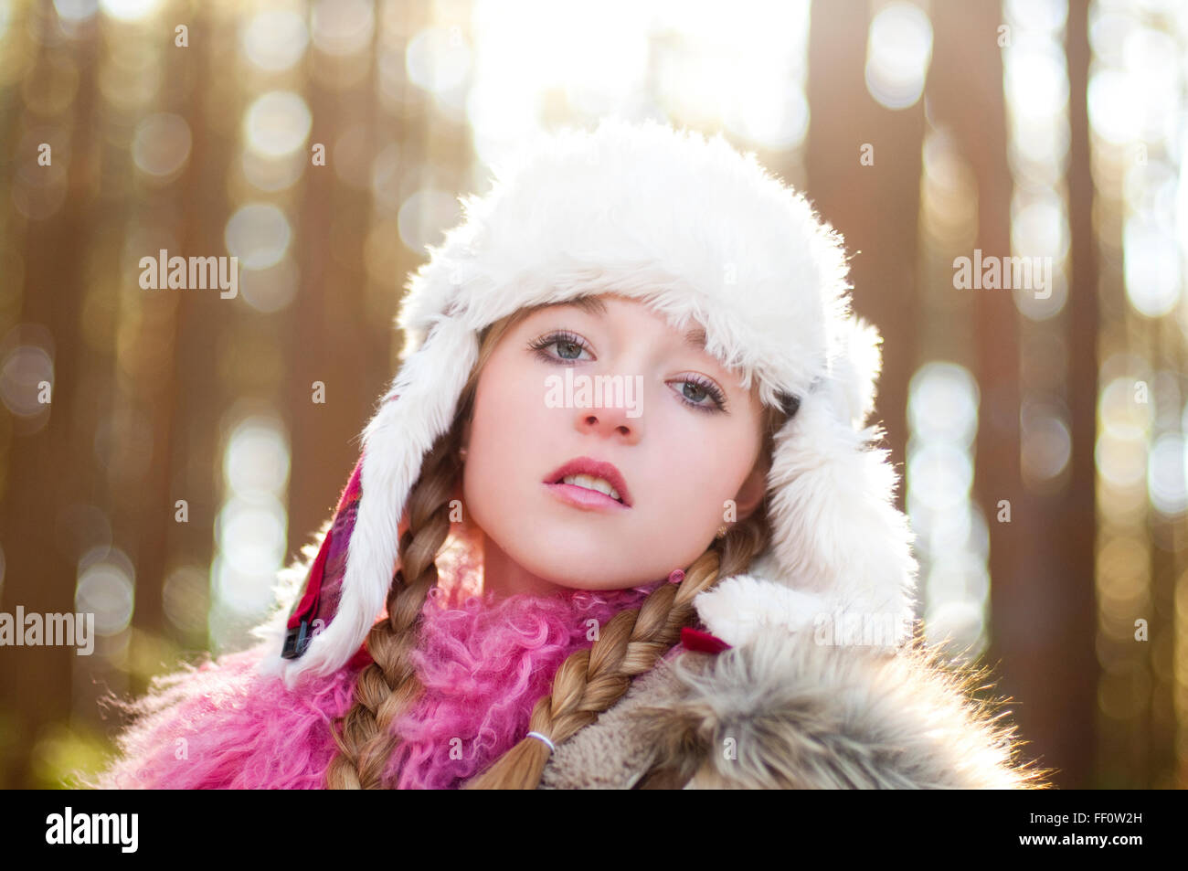 Caucasian teenage girl wearing fuzzy hat outdoors Stock Photo