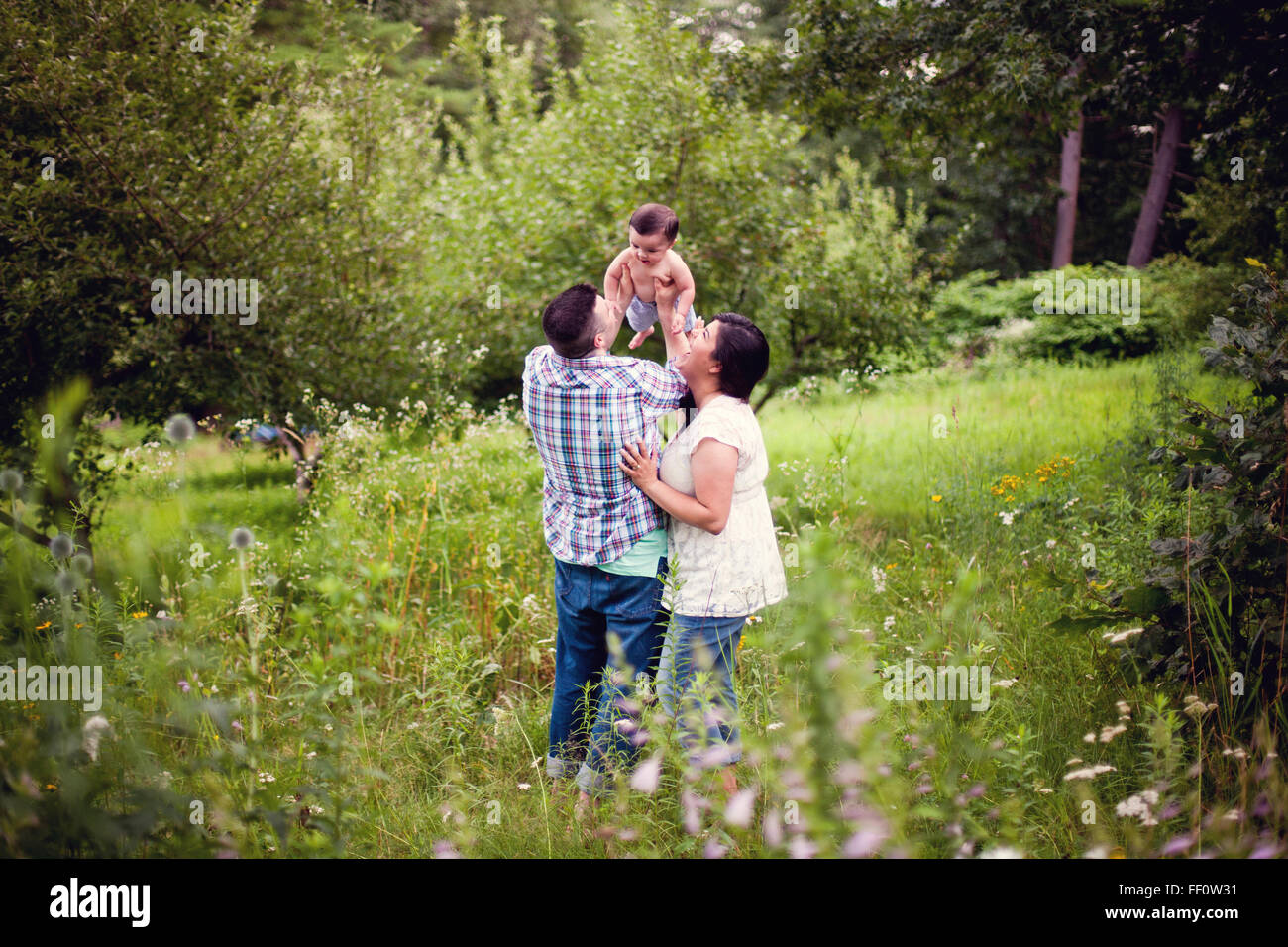 Parents holding baby in garden Stock Photo