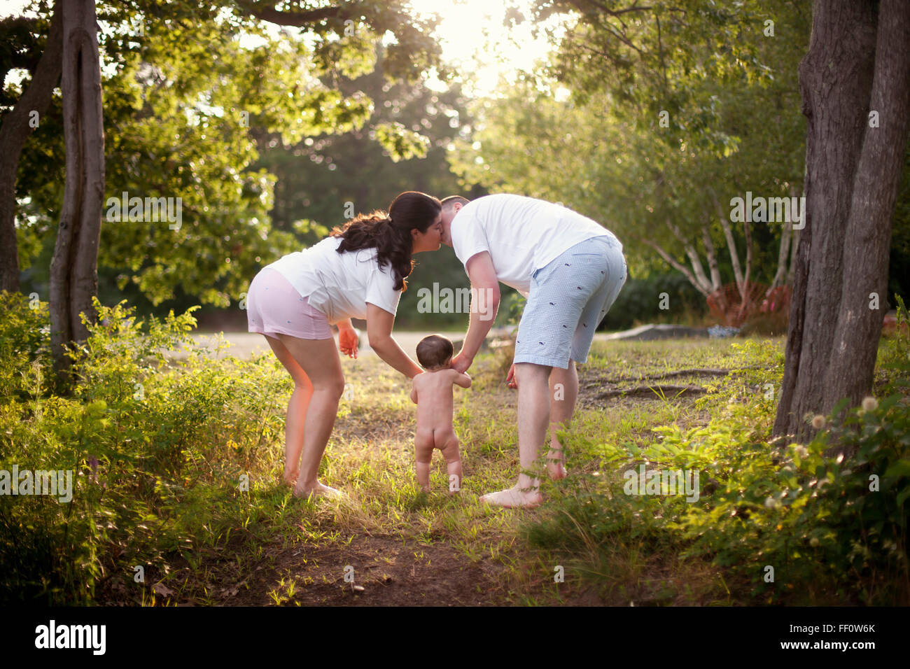 Parents and baby walking in garden Stock Photo