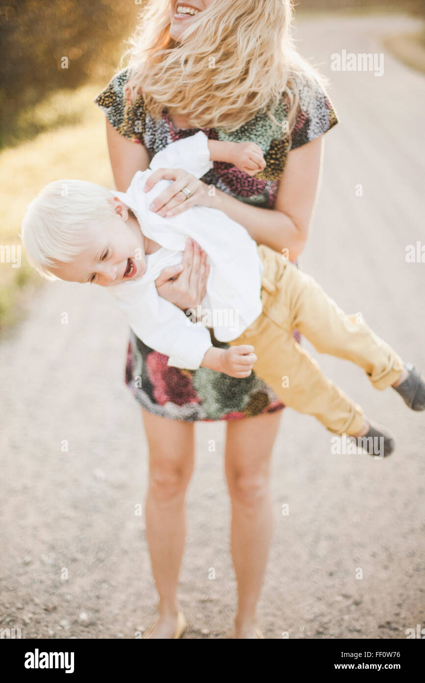 Mother lifting son outdoors Stock Photo