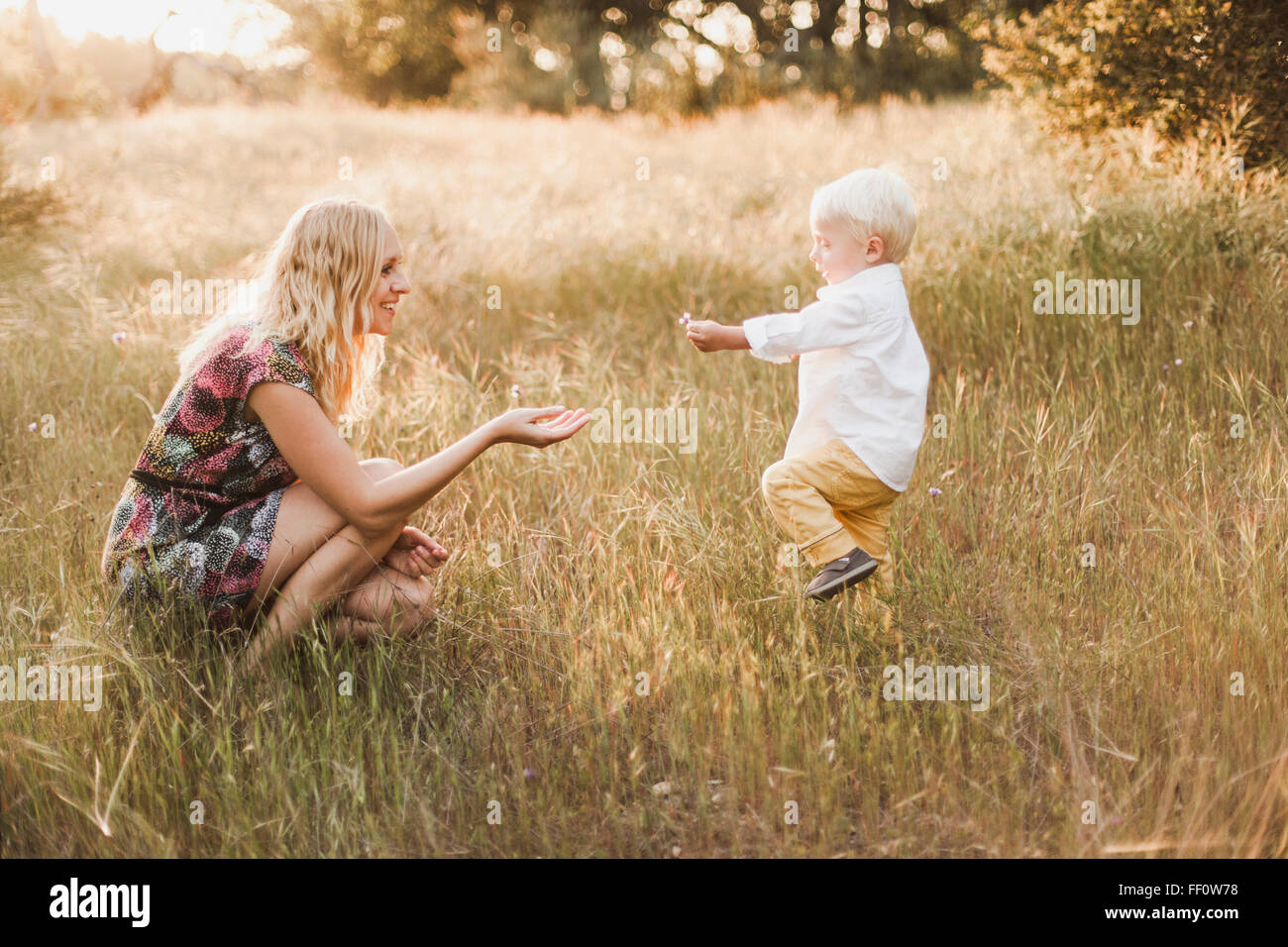 Mother and son playing in field Stock Photo