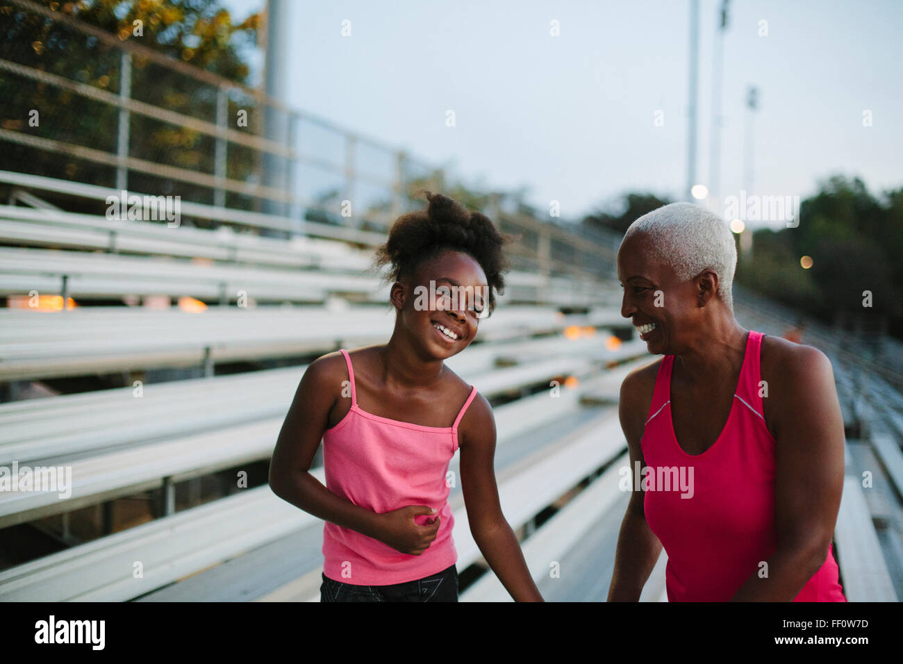 Grandmother and granddaughter standing on bleachers Stock Photo