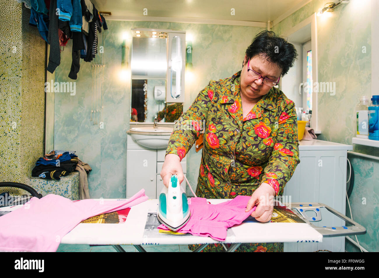 Caucasian woman ironing laundry Stock Photo