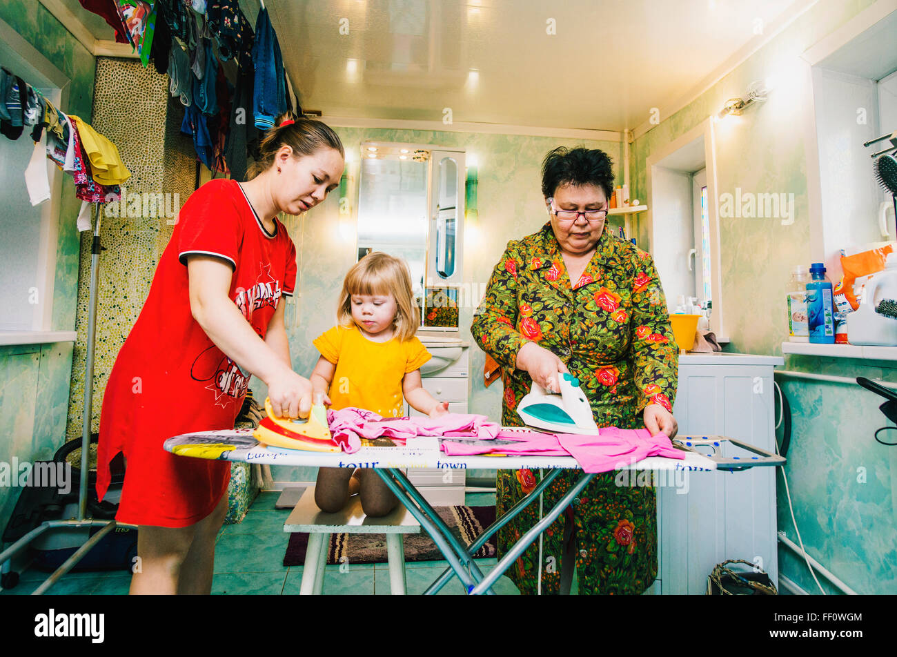 Caucasian women ironing laundry Stock Photo