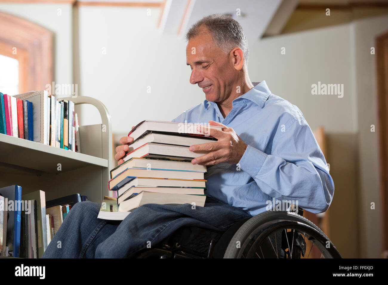 Caucasian man choosing book in library Stock Photo