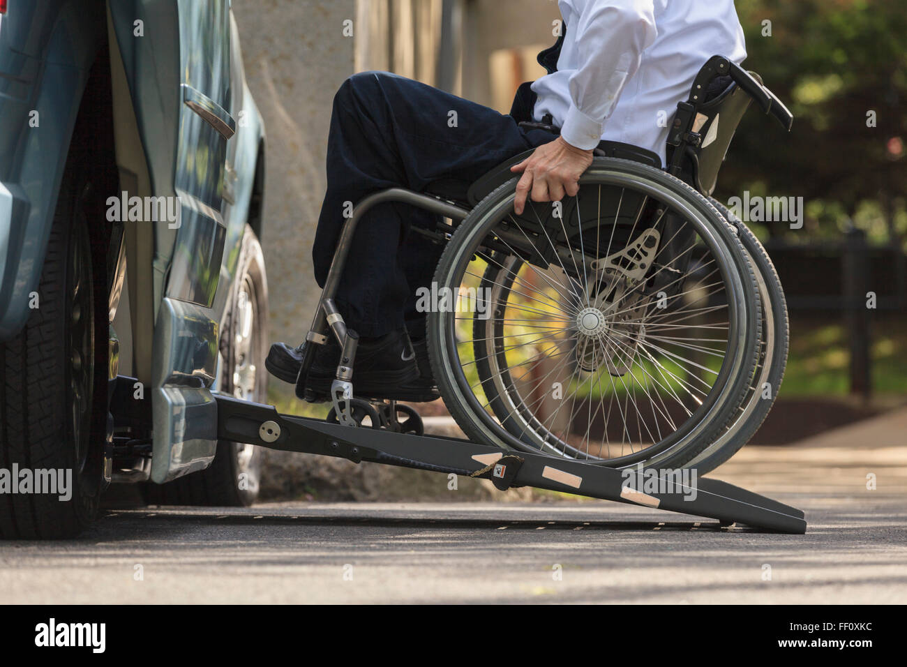 Caucasian businessman in wheelchair entering van Stock Photo