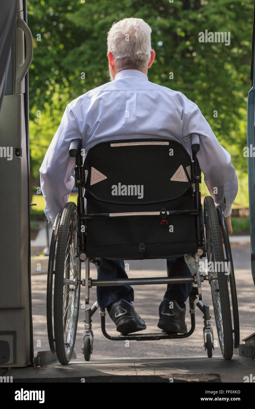 Caucasian businessman in wheelchair exiting van Stock Photo