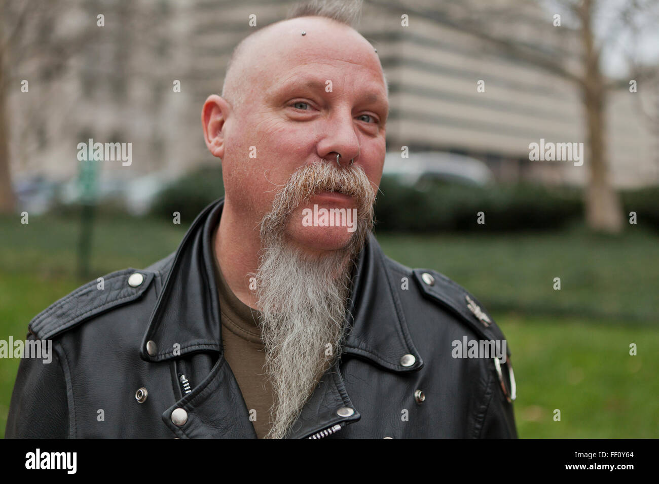 Middle aged Caucasian man sporting leather jacket and gray beard - USA Stock Photo