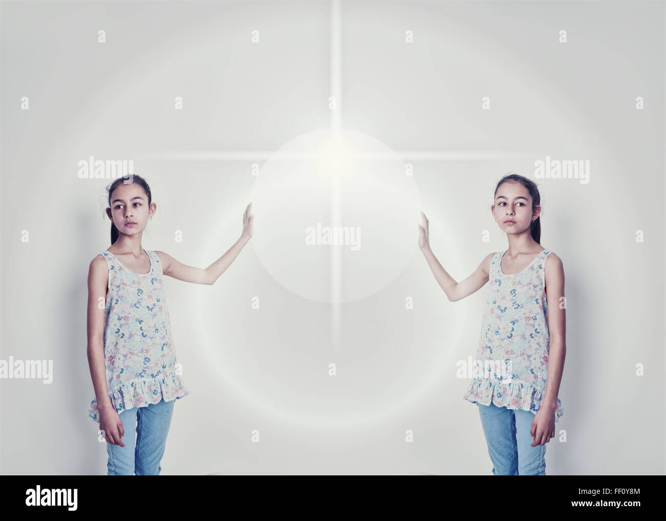 Mirror image of mixed race girl reaching for light Stock Photo