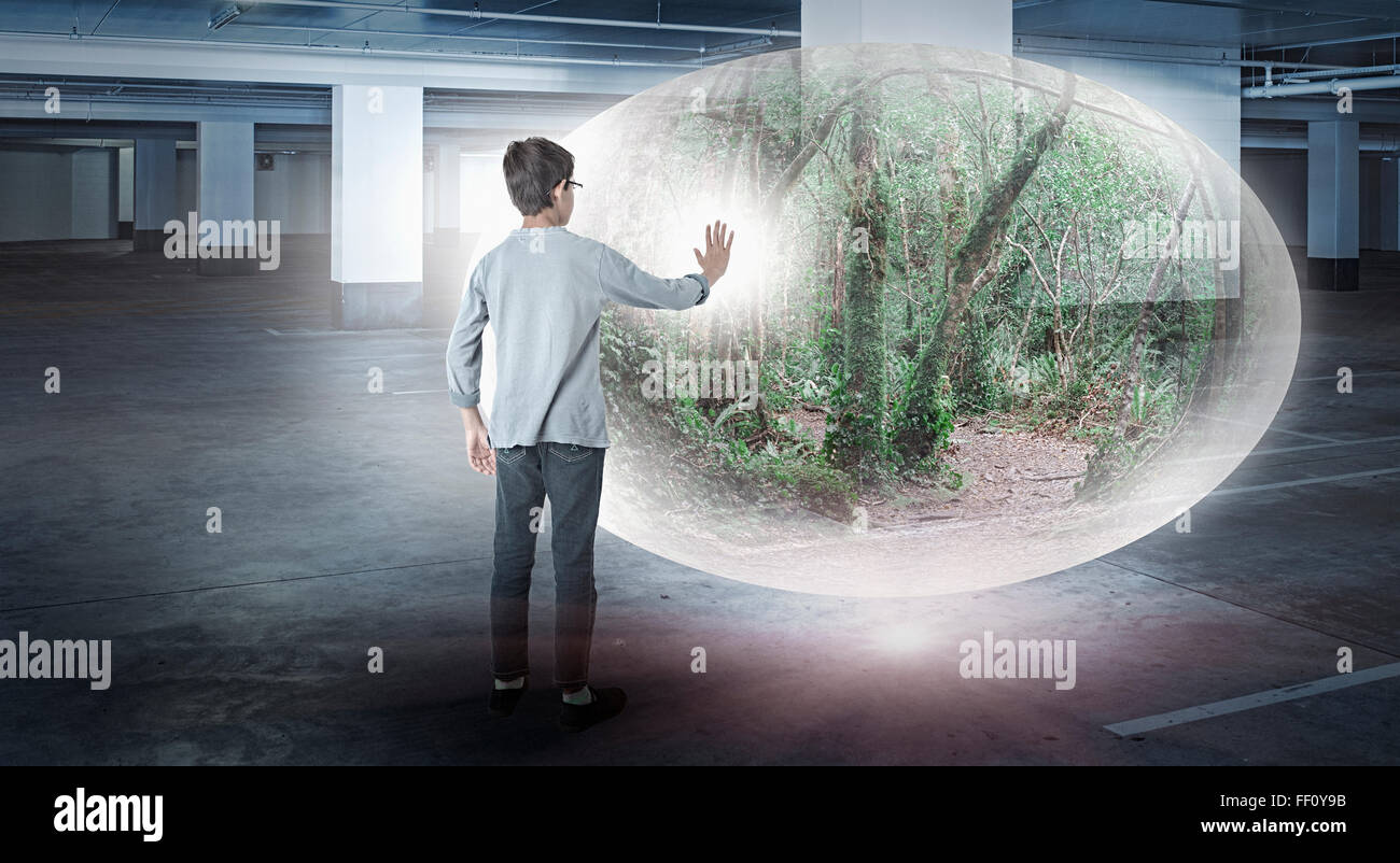 Mixed race boy with forest globe in parking lot Stock Photo