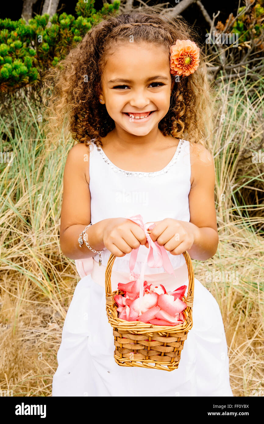 Mixed race girl carrying flower basket Stock Photo