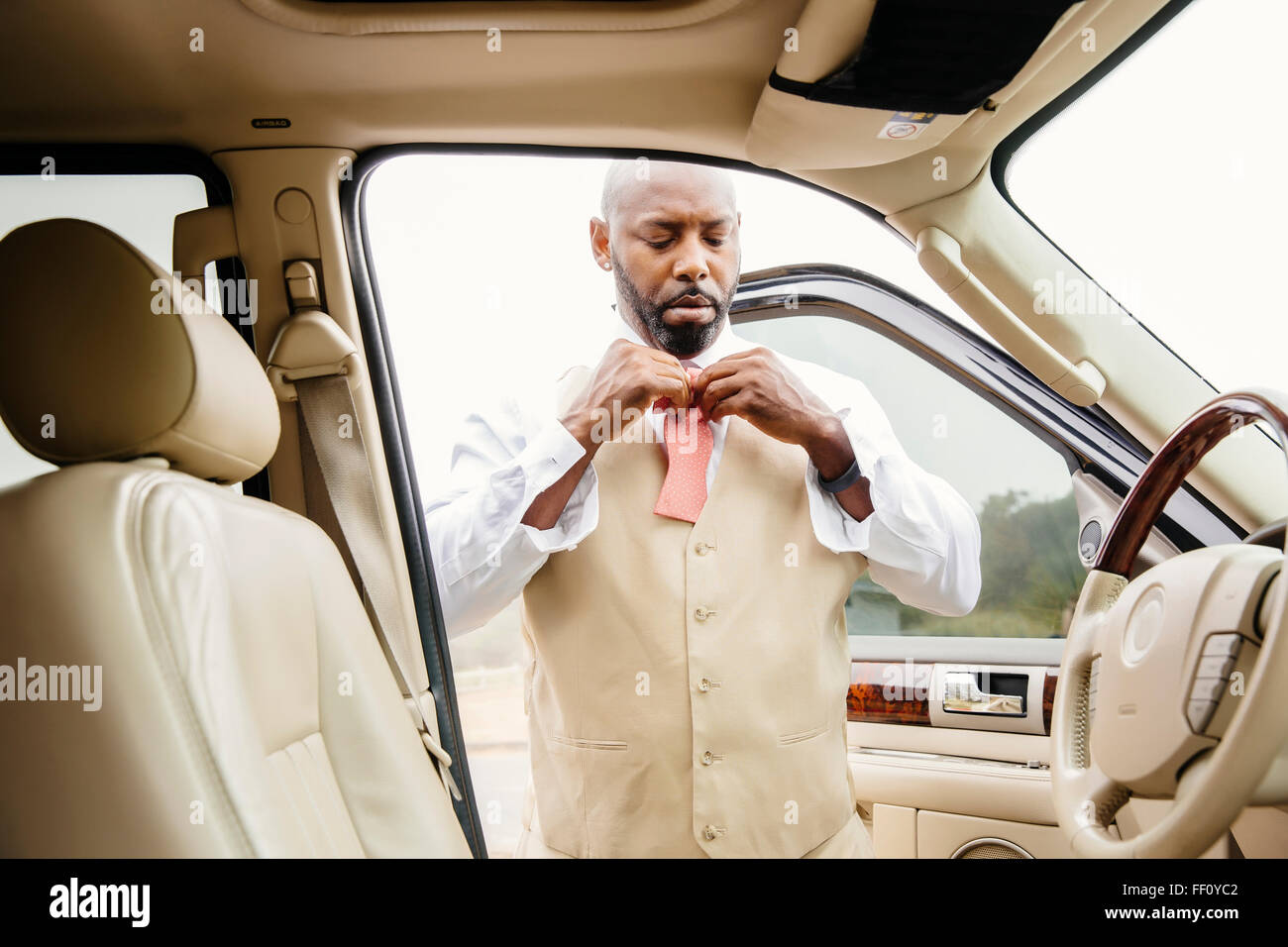 Black man tying bow tie in car Stock Photo Alamy