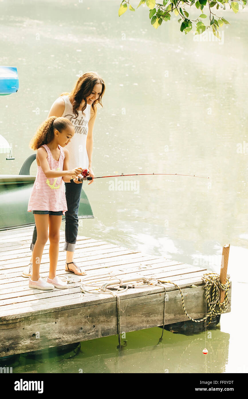 Mother and daughter fishing in lake Stock Photo