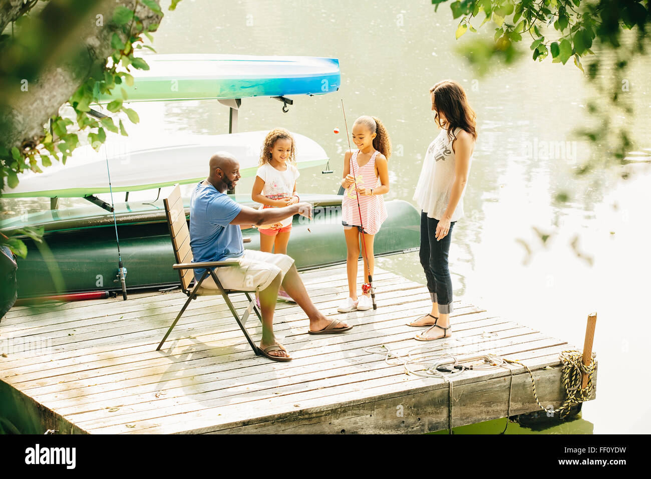 Family standing on dock in lake Stock Photo