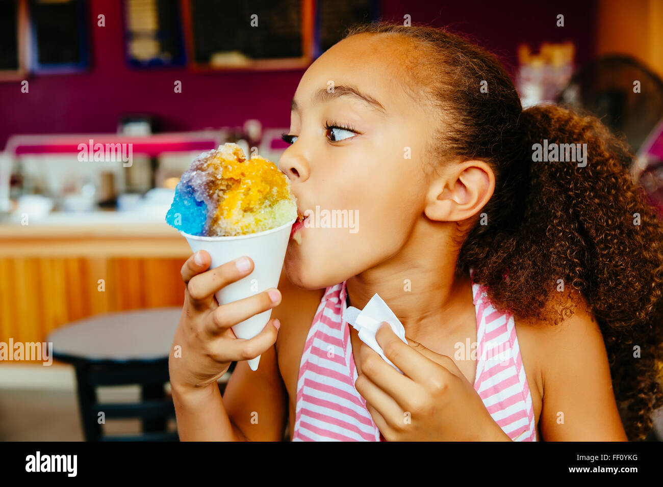 Mixed race girl eating snow cone Stock Photo