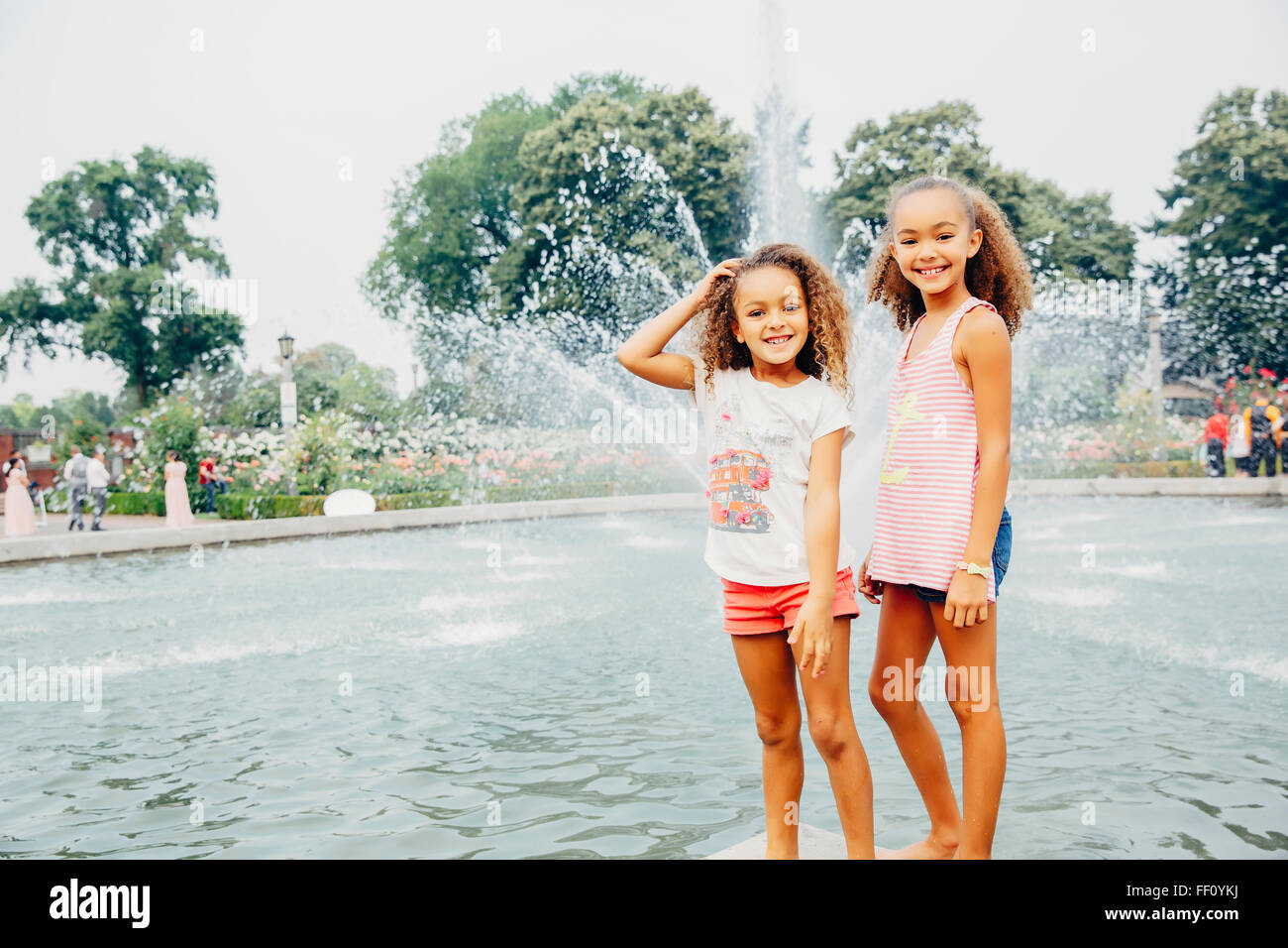 Mixed race sisters smiling in park Stock Photo