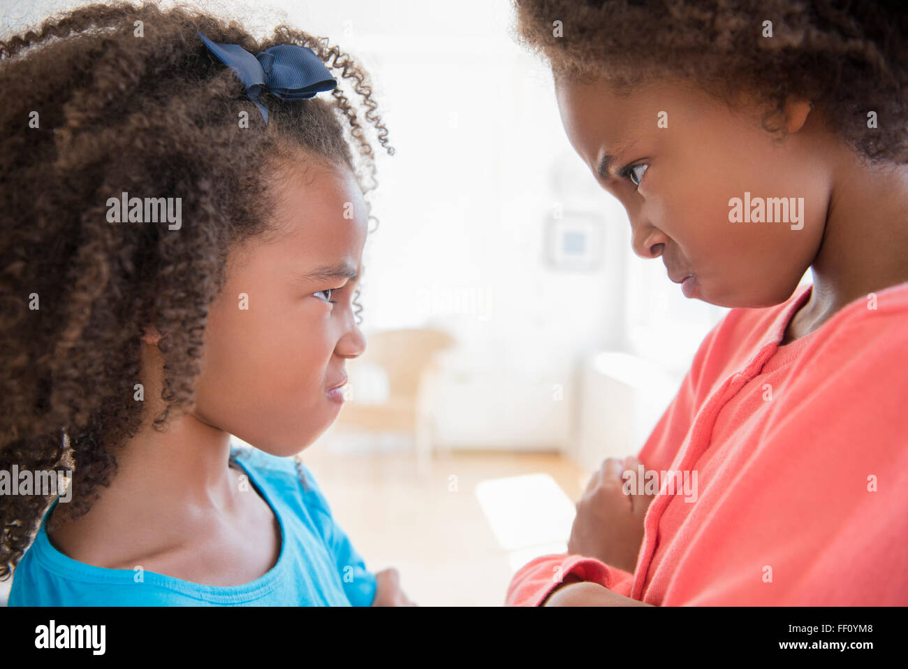 Mixed race sisters scowling Stock Photo