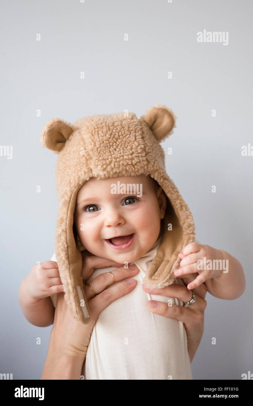 Caucasian mother holding baby daughter in fuzzy hat Stock Photo