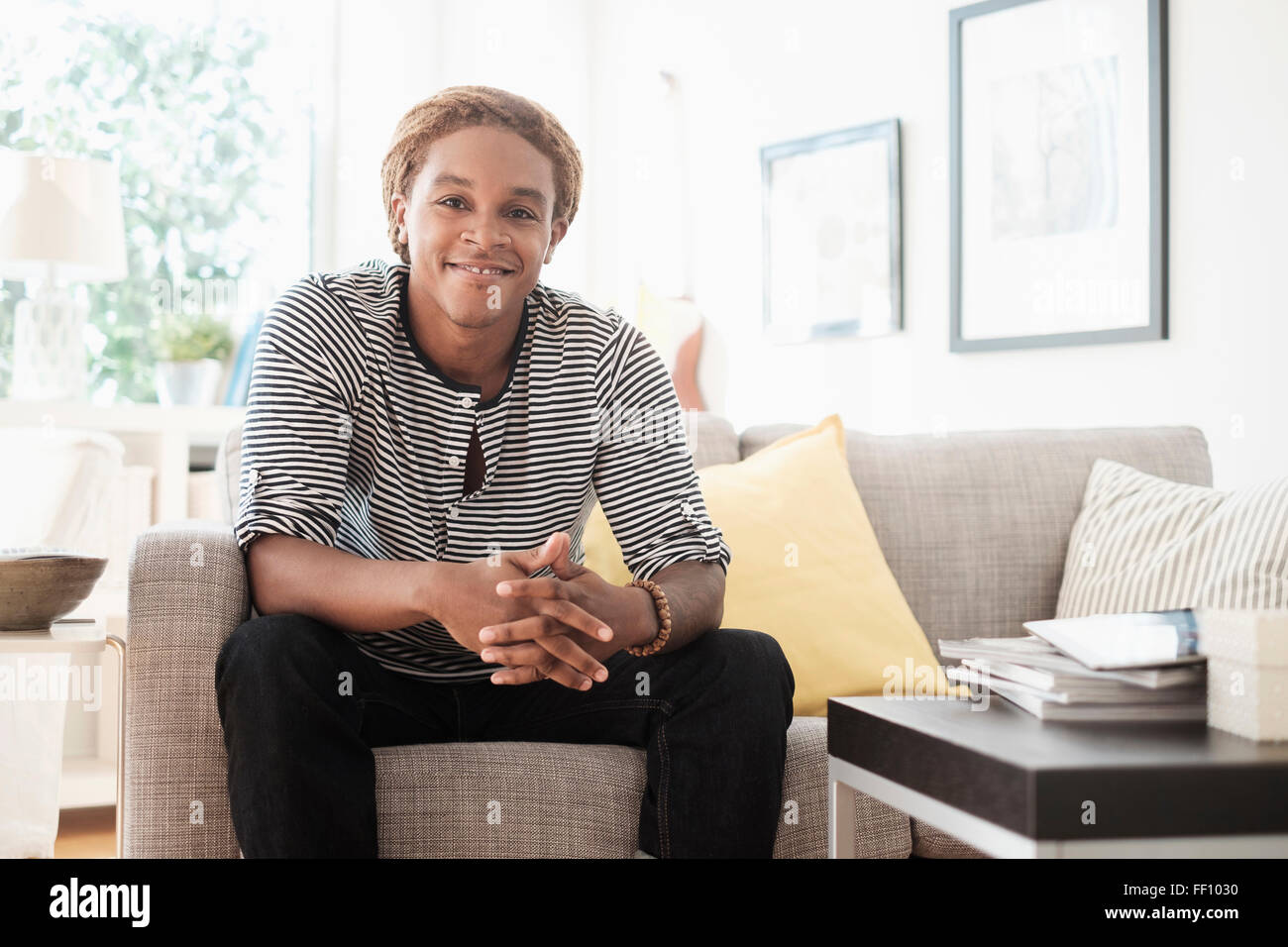 Man sitting couch smiling hi-res stock photography and images - Alamy