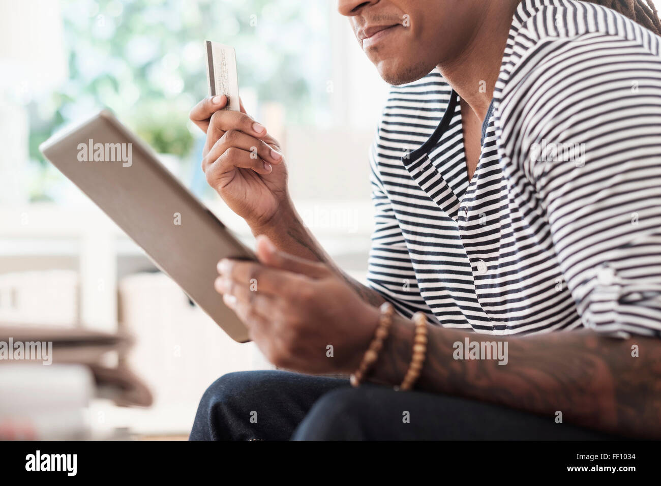 Mixed race man shopping online with digital tablet Stock Photo