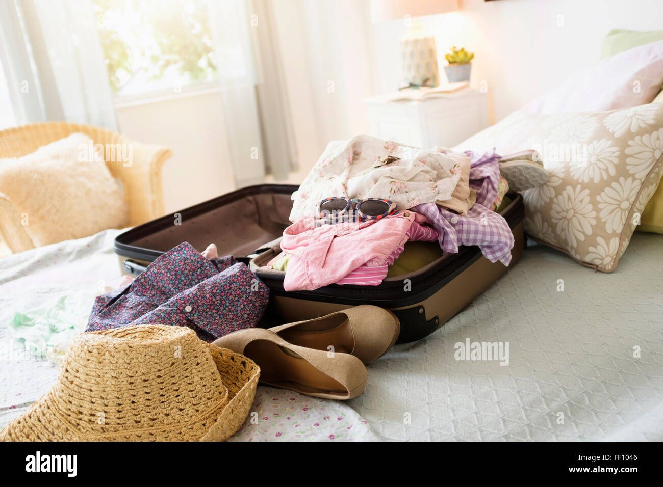 Messy suitcase on bed Stock Photo