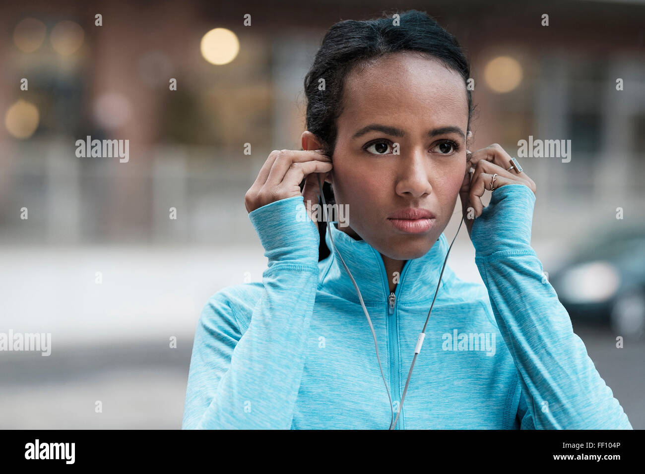 Mixed race runner listening to earbuds Stock Photo