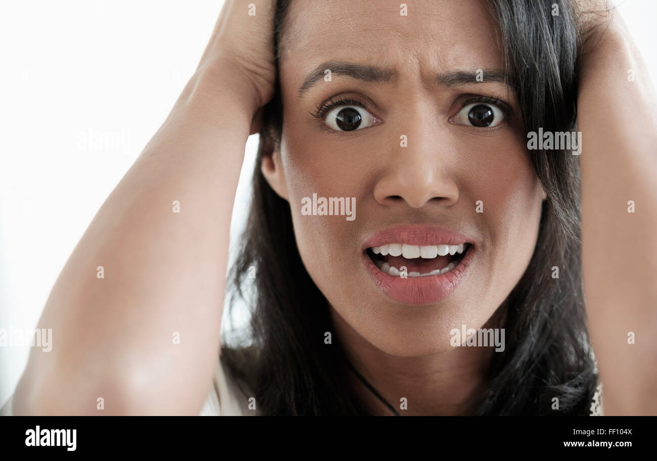 Close up of mixed race woman gasping Stock Photo