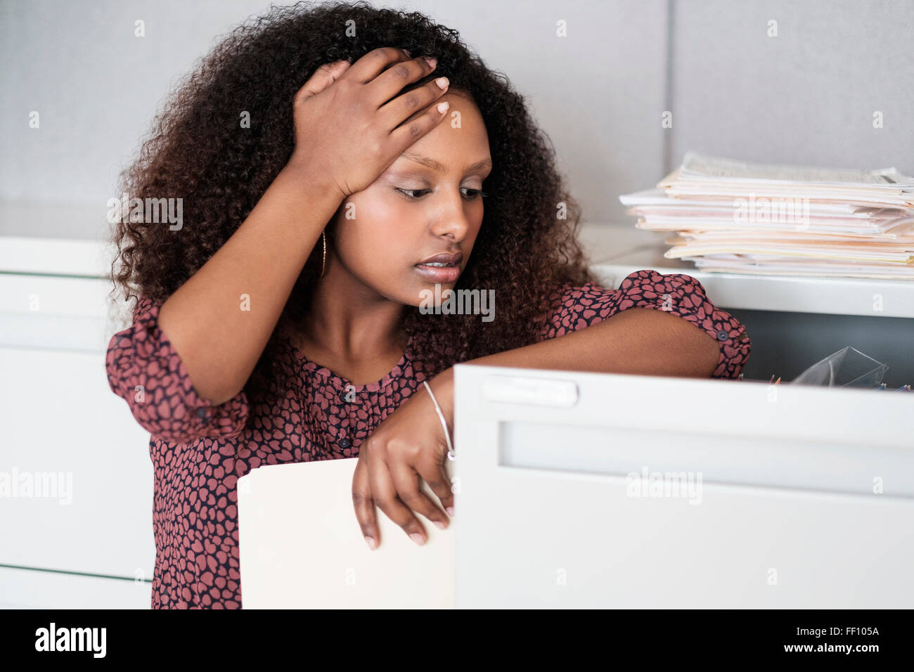 Black businesswoman searching in filing cabinet Stock Photo