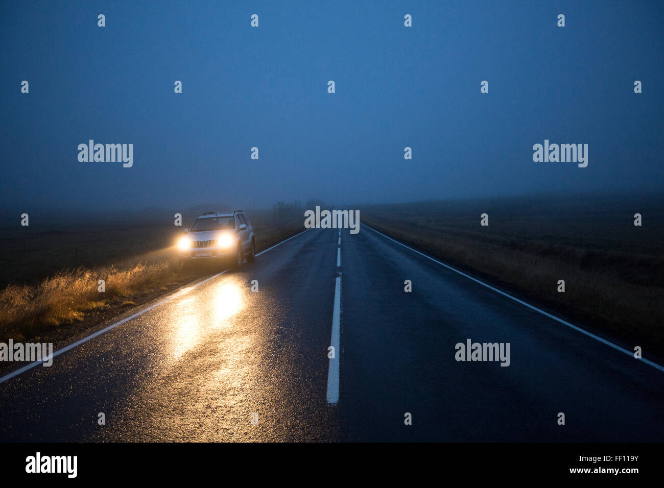 Car on remote road at night Stock Photo