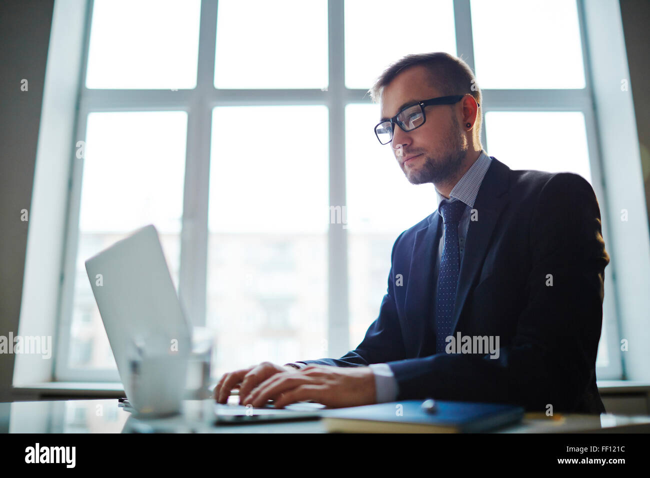 Confident young businessman analyzing electronic data in office Stock ...