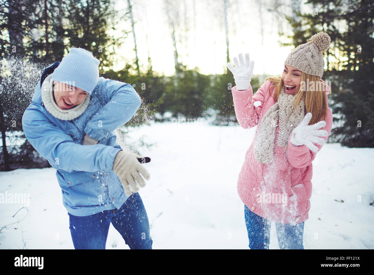 Joyful couple playing snowballs in park Stock Photo - Alamy