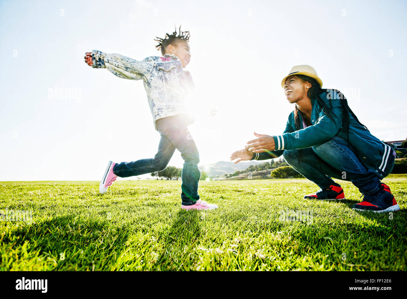 Black mother and daughter playing in park Stock Photo