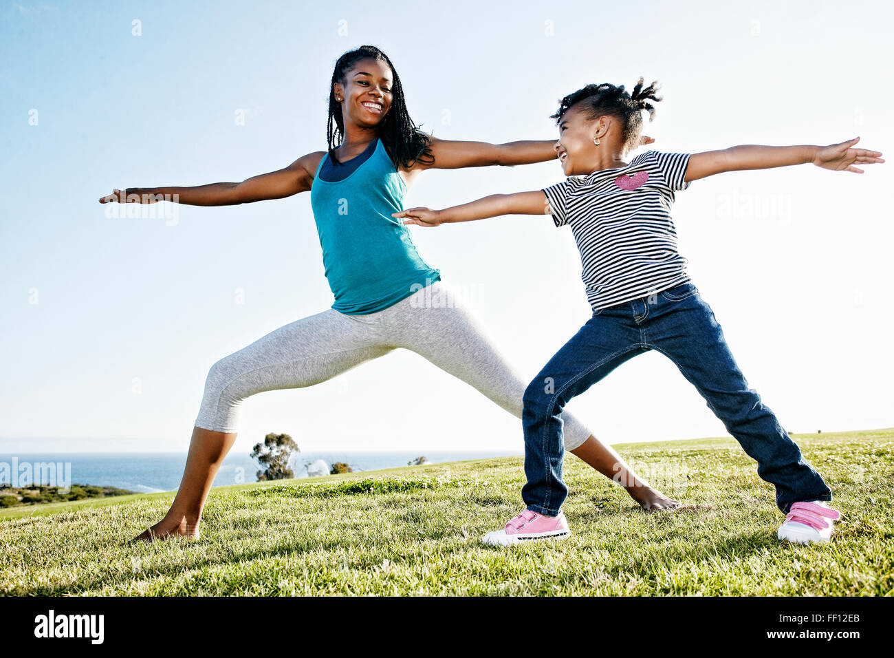Black mother and daughter practicing yoga Stock Photo - Alamy