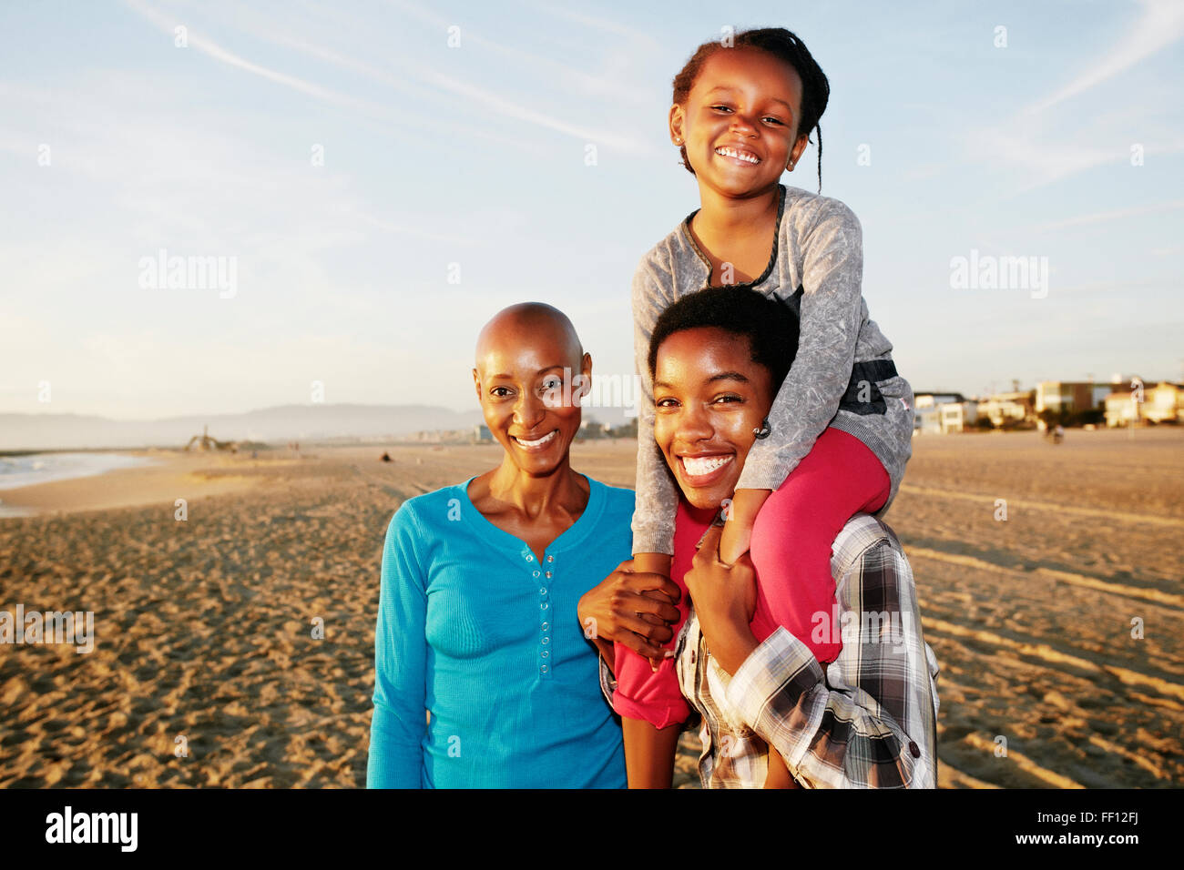 Three generations of Black women smiling on beach Stock Photo