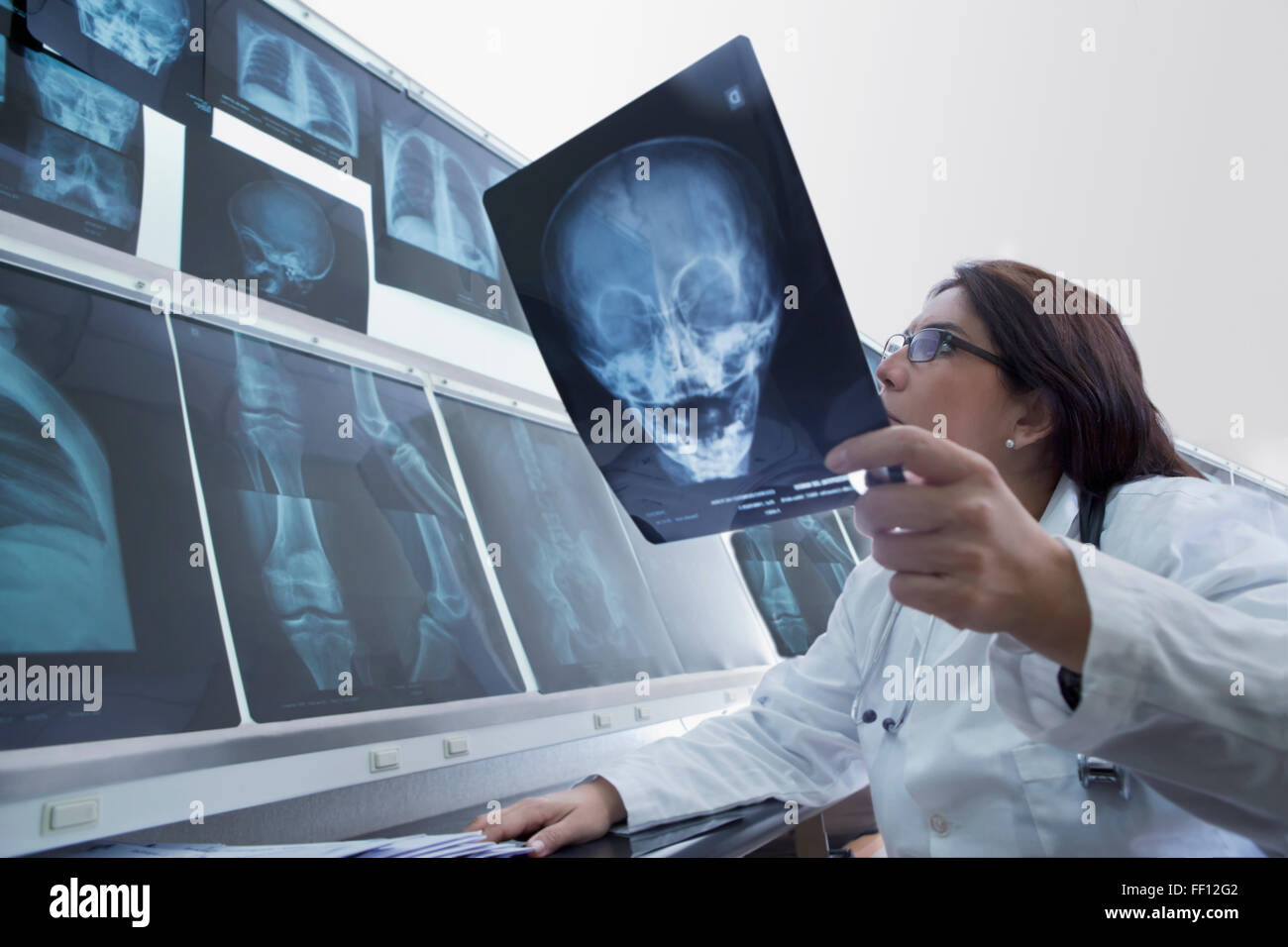 Hispanic doctor examining xrays in hospital Stock Photo Alamy