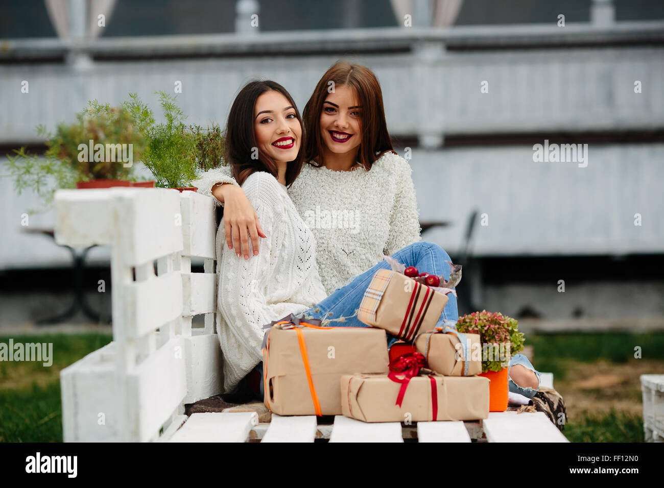 Two beautiful girls sitting on a bench Stock Photo - Alamy
