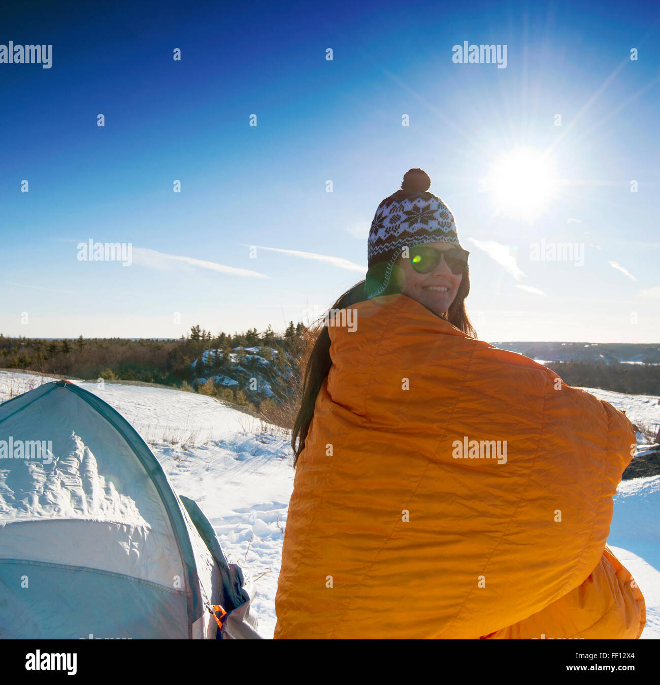 Hiker standing at snowy campsite Stock Photo