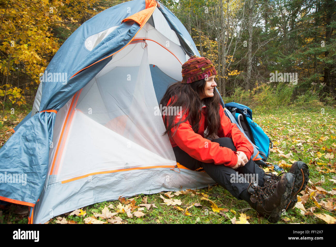 Hiker sitting in tent at campsite Stock Photo