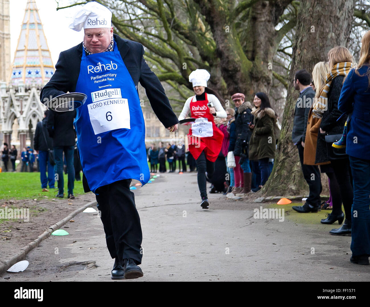 Westminster, London, United Kingdom. February 9th, 2016 - Lord Kennedy of Southwark and Mia Reakes of Reuters TV runs at the Parliamentary pancake race in aid of the disability charity, Rehab  Credit:  Dinendra Haria/Alamy Live News Stock Photo