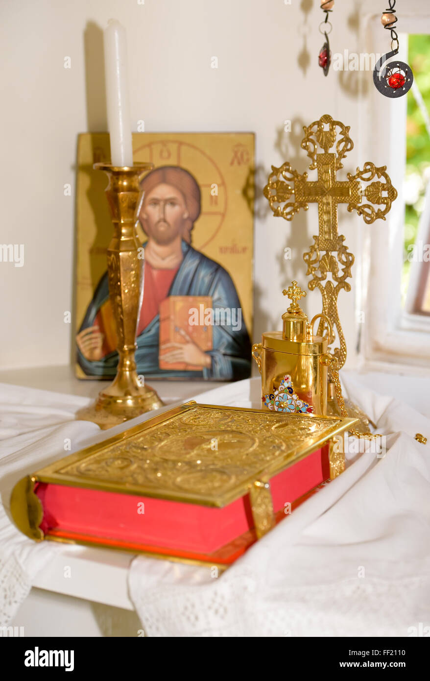 Interior of a very small greek chapel with holy bible, golden cross and oil for baptism Stock Photo