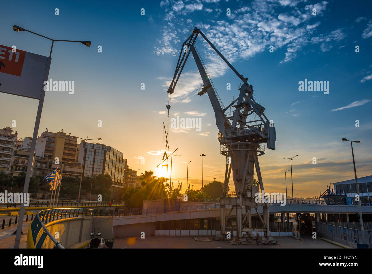 Old sea port crane at sunset in Port of Piraeus, Greece. Wide angle view. Stock Photo