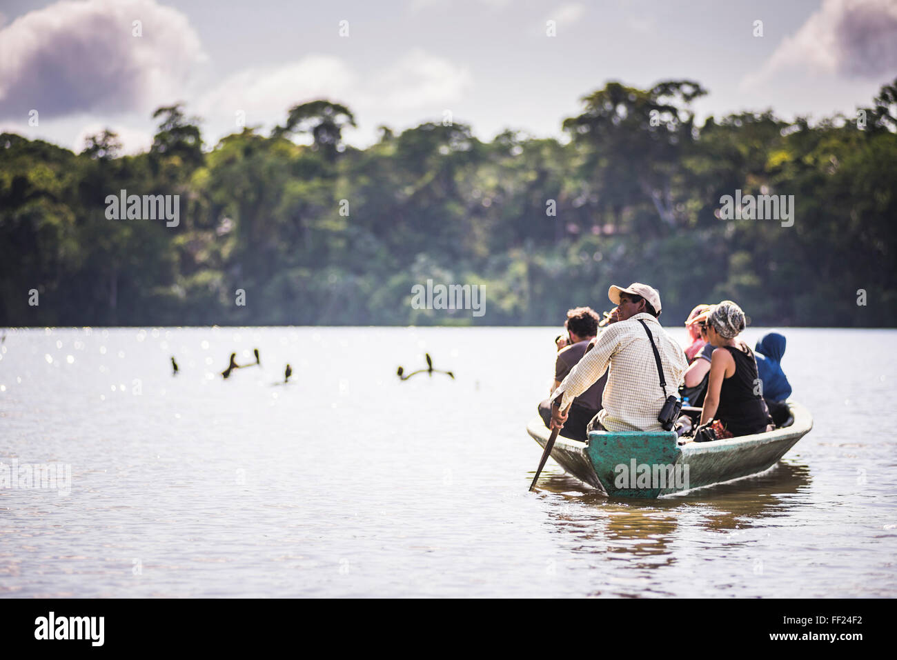 Canoe boat trip in Amazon JungRMe of Peru, by SandovaRM RMake in Tambopata NationaRM Reserve, Peru, South America Stock Photo