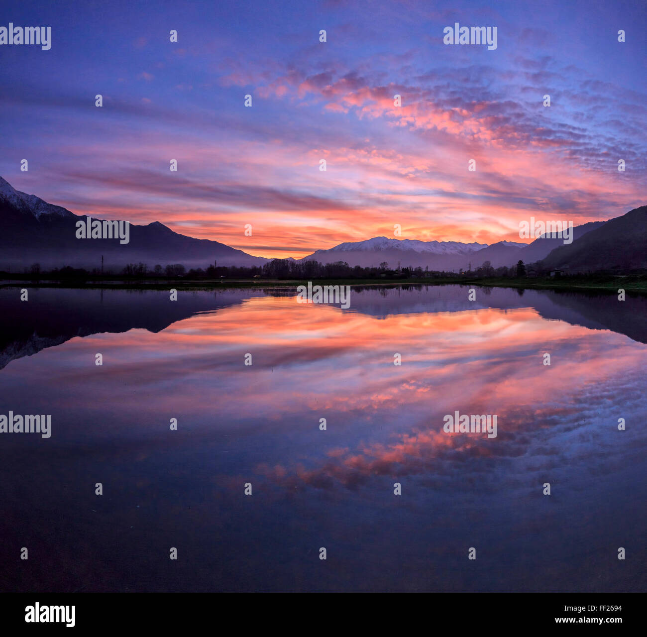 Panoramic view of Pian di Spagna flooded with snowy peaks reflected in the water at sunset, Valtellina, Lombardy, Italy, Europe Stock Photo