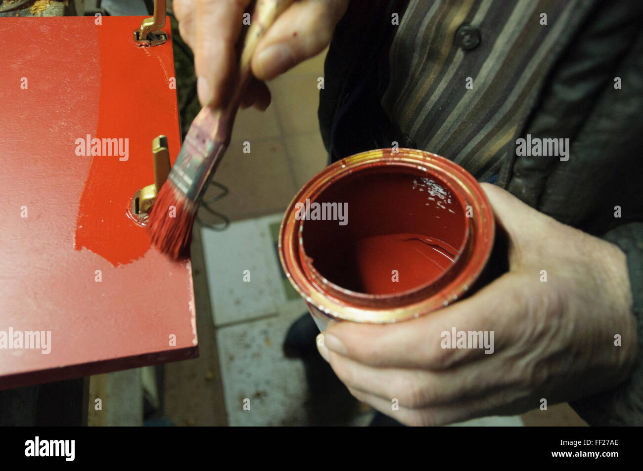 Man  painting a red door with a brush Stock Photo