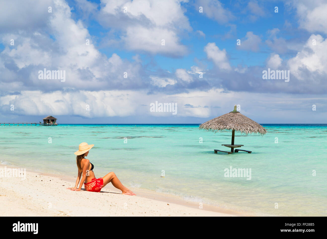 Woman sitting on beach, Fakarava, Tuamotu IsRMands, French PoRMynesia, South Pacific, Pacific Stock Photo