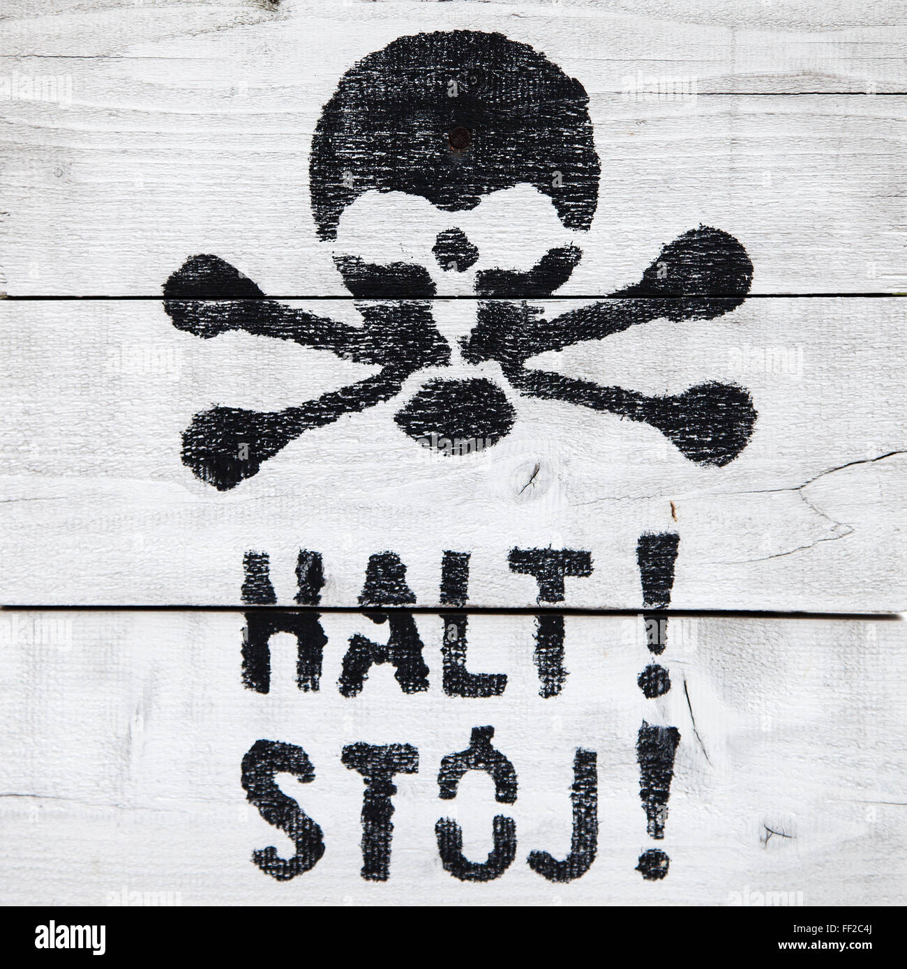 Halt! Stoj! Stop sign, in german and polish, with a painted skull. Stock Photo