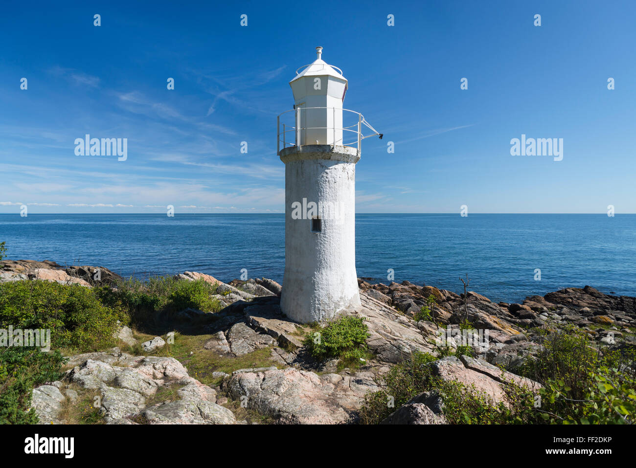 White lighthouse,blue sea and sky in bright sunlight at Stenshuvud National Park at the Baltic Sea coast in Skane, Sweden Stock Photo